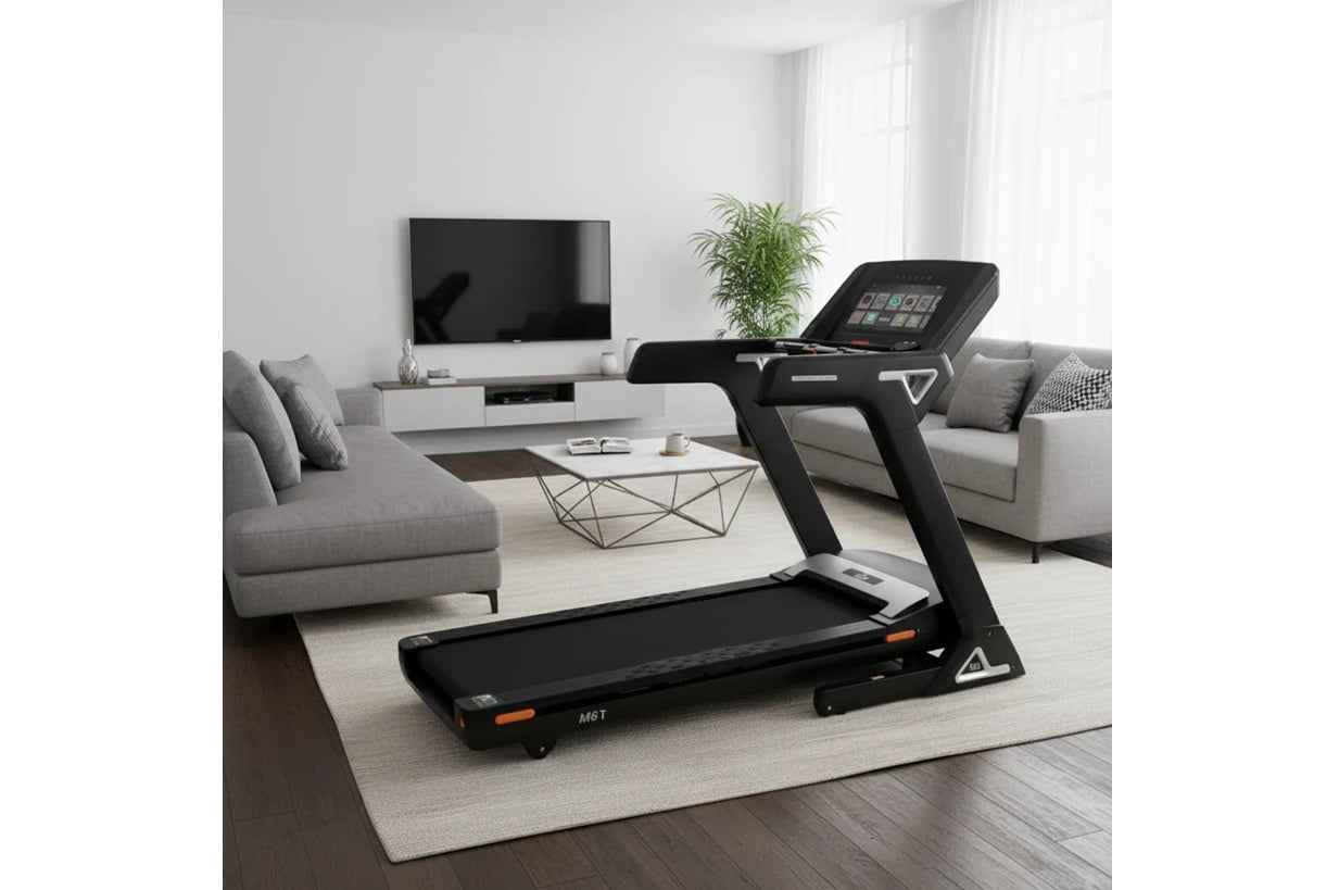 Black and orange folding treadmill with touch console display in modern living room setting