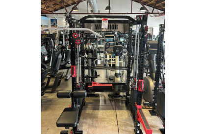 Black and red Warrior cable crossover pulley power rack with lat pulldown attachment in gym facility, front view