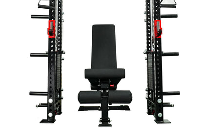 Black and red cable crossover power rack gym system with adjustable pulley arms, weight plates, and padded bench seat on whit